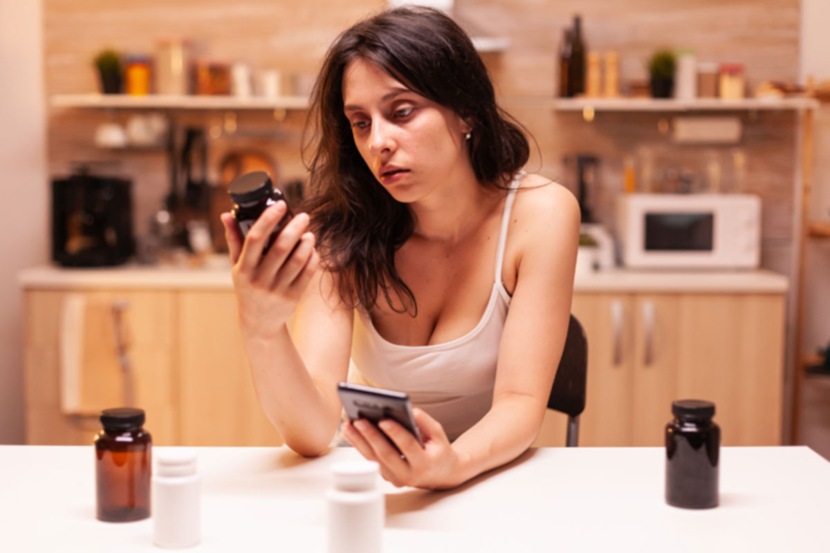 Køb melatonin online fra Vitasunn Nutritionals En kvinde sammenligner melatonintilskud online derhjemme ved hjælp af sin smartphone